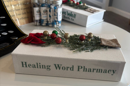 Decorative box labeled 'Healing Word Pharmacy' with a wreath on top, placed on a surface.