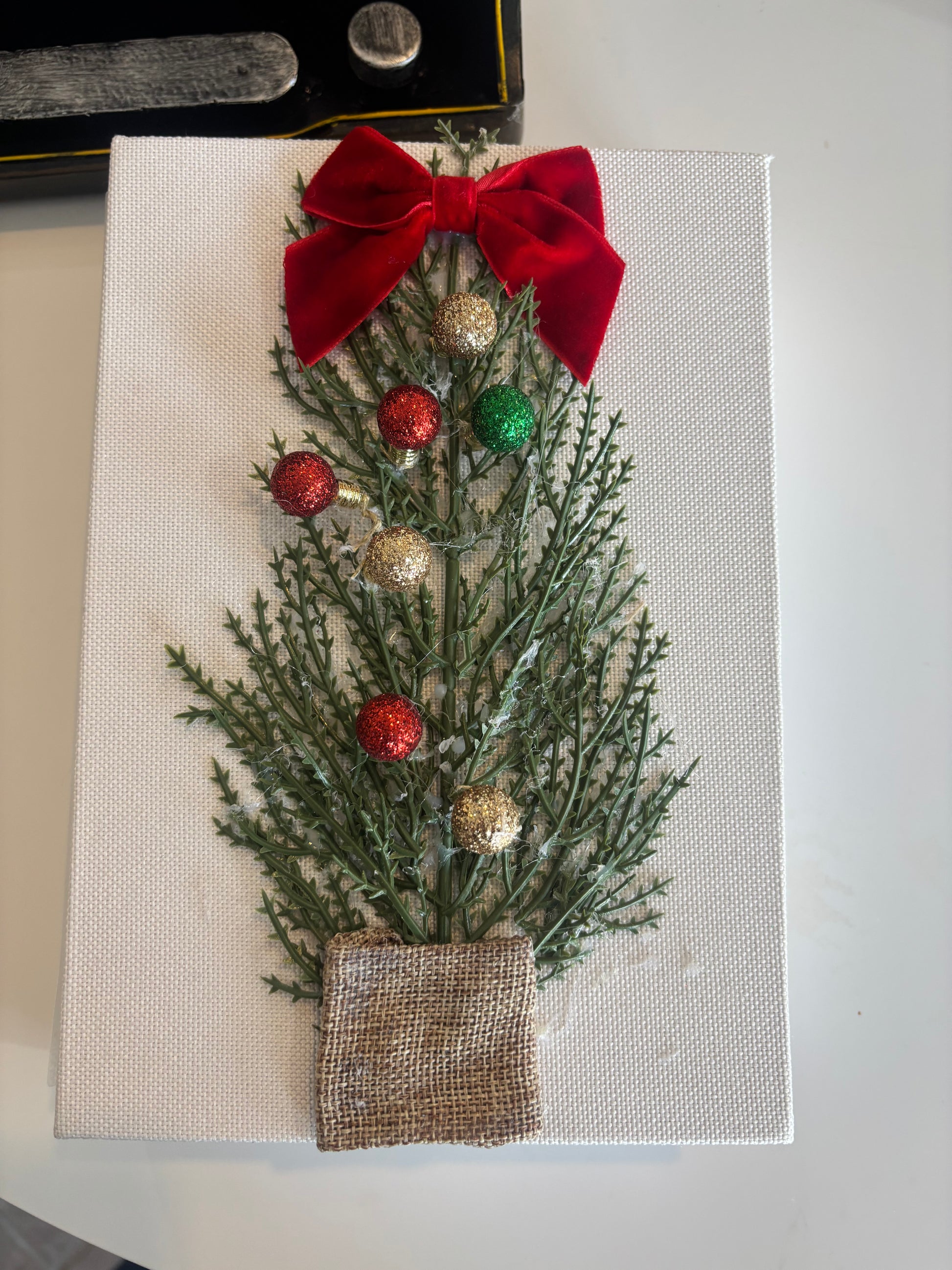 Decorative Christmas card with greenery, red bow, and gold ornaments on a white background.